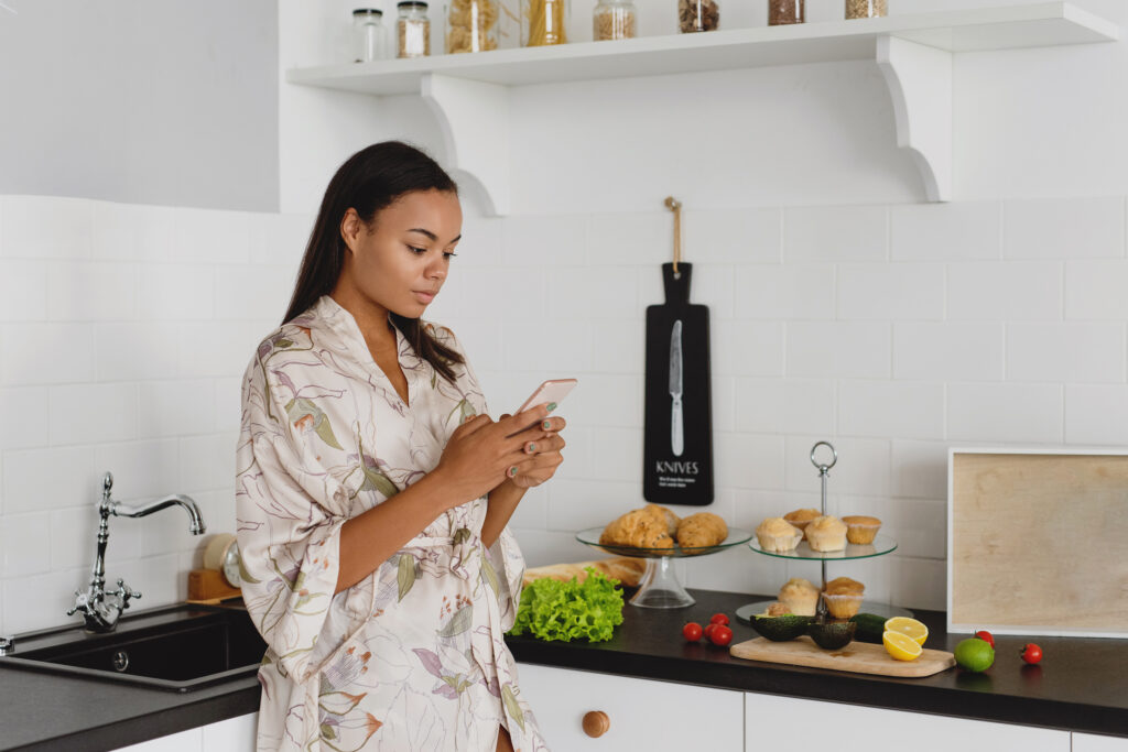 Busy working woman reviewing her Sunday prep checklist in a bright kitchen with groceries and meal prep items.