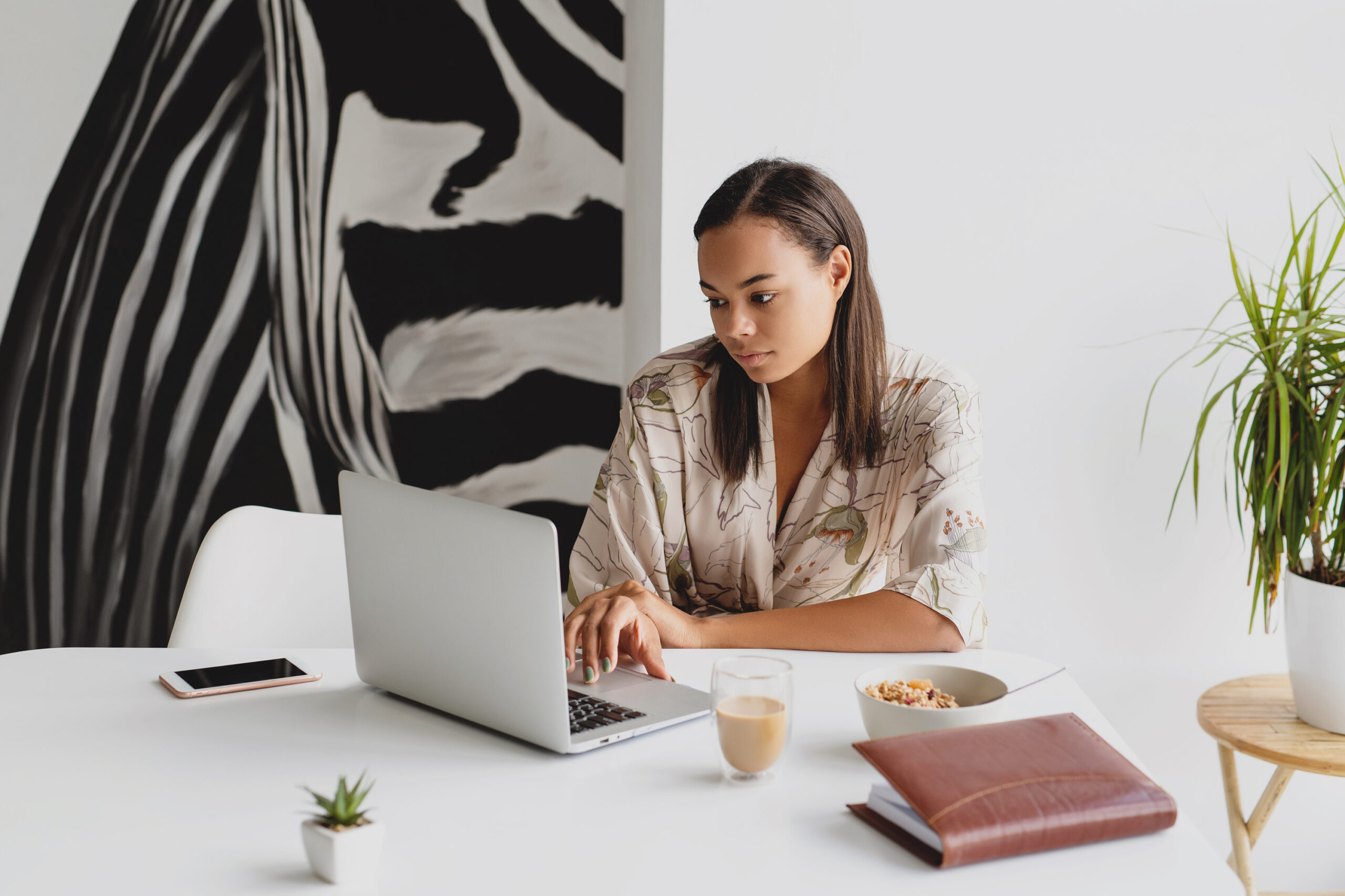 Working woman planning her week on a laptop at a clean desk during a Sunday reset routine.